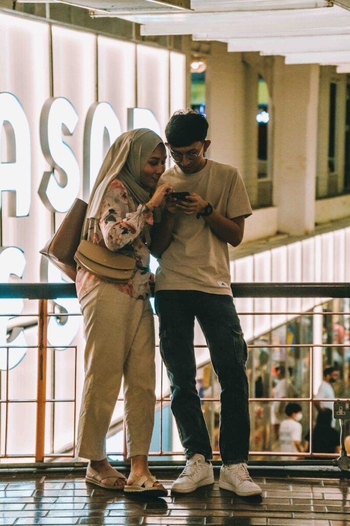 Two people are looking at a phone together.