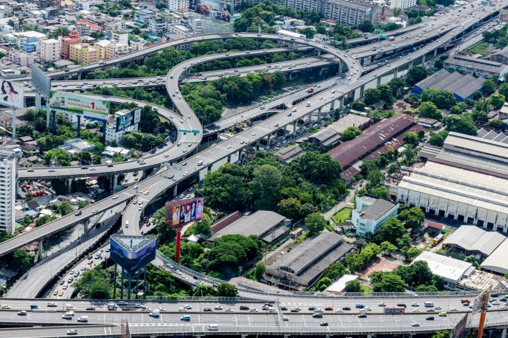 Aerial photo of complex highway interchanges in an urban cityscape.