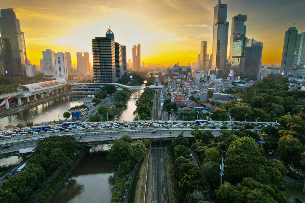 A stunning aerial view of South Jakarta at sunset, showcasing skyscrapers, traffic, and vibrant urban life.