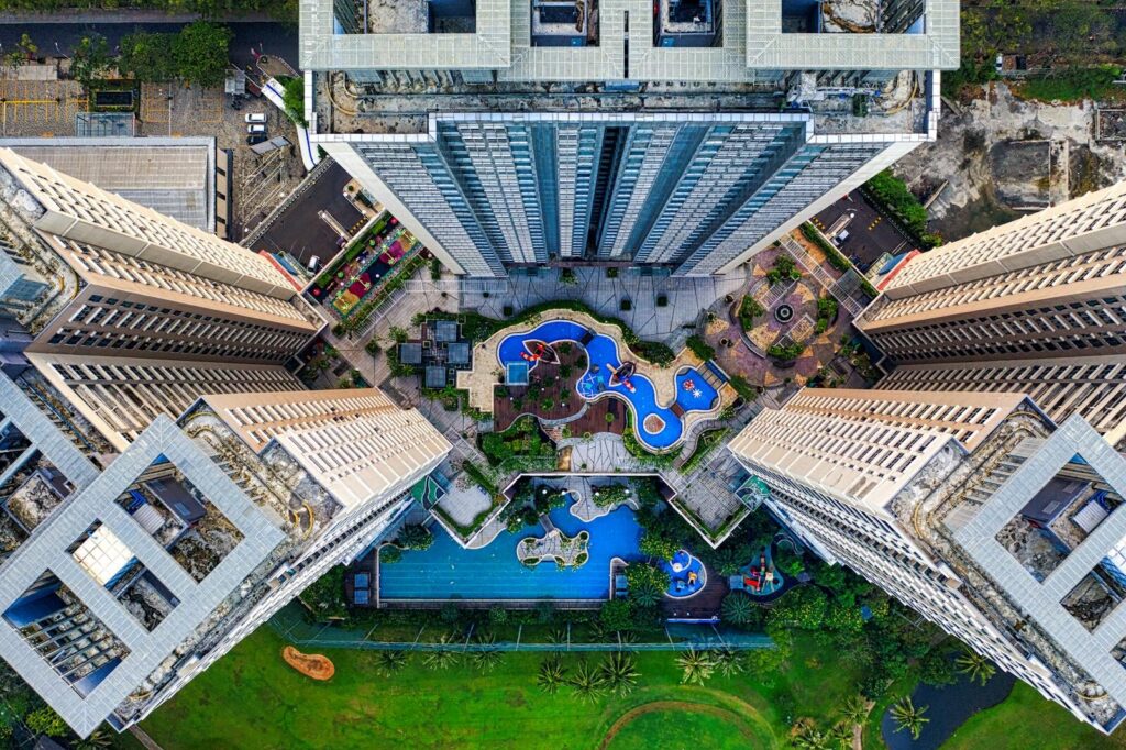Drone shot capturing high-rise buildings and swimming pools in Jakarta, Indonesia, from above.