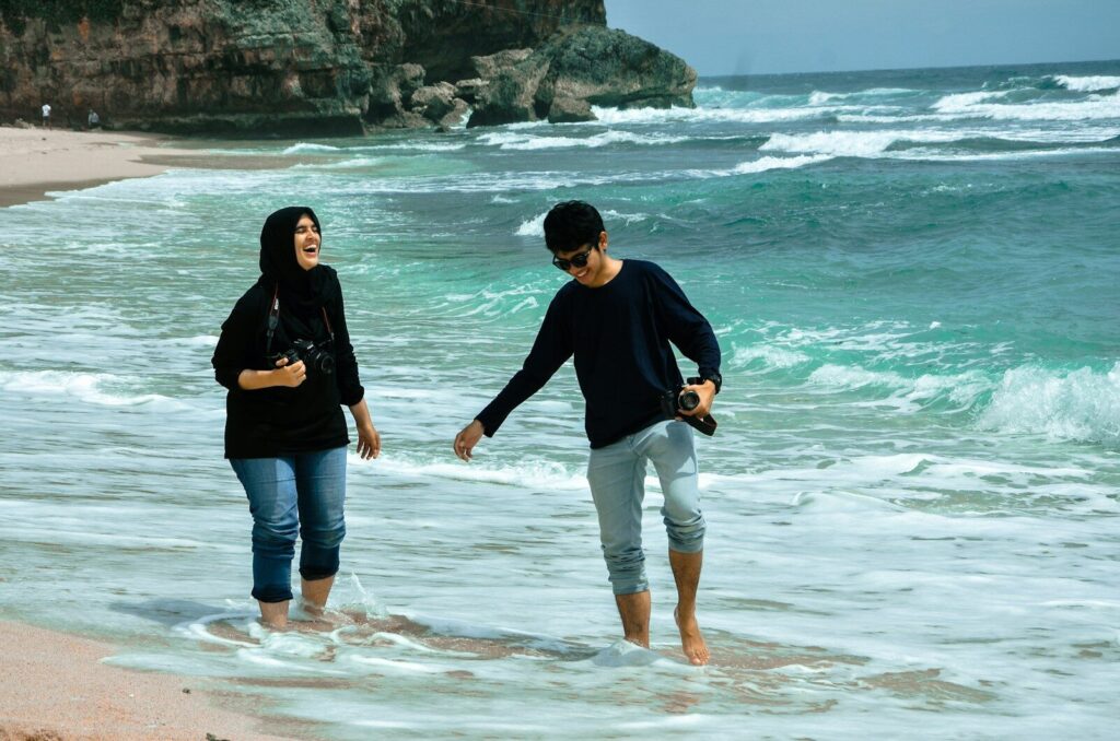 man and woman standing on beach during daytime