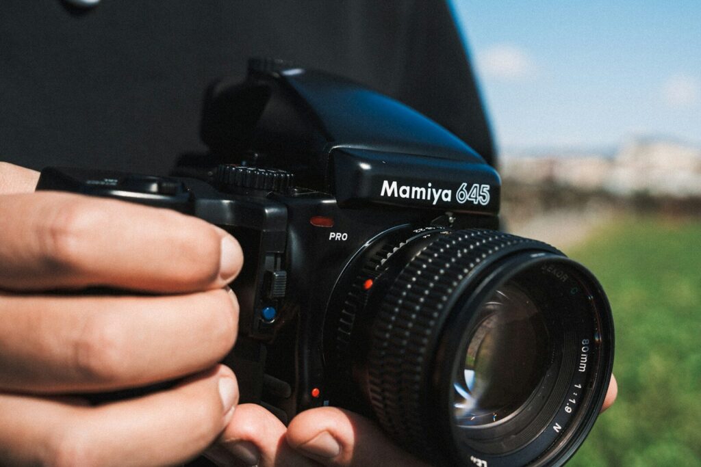 Hands holding a vintage mamiya 645 camera