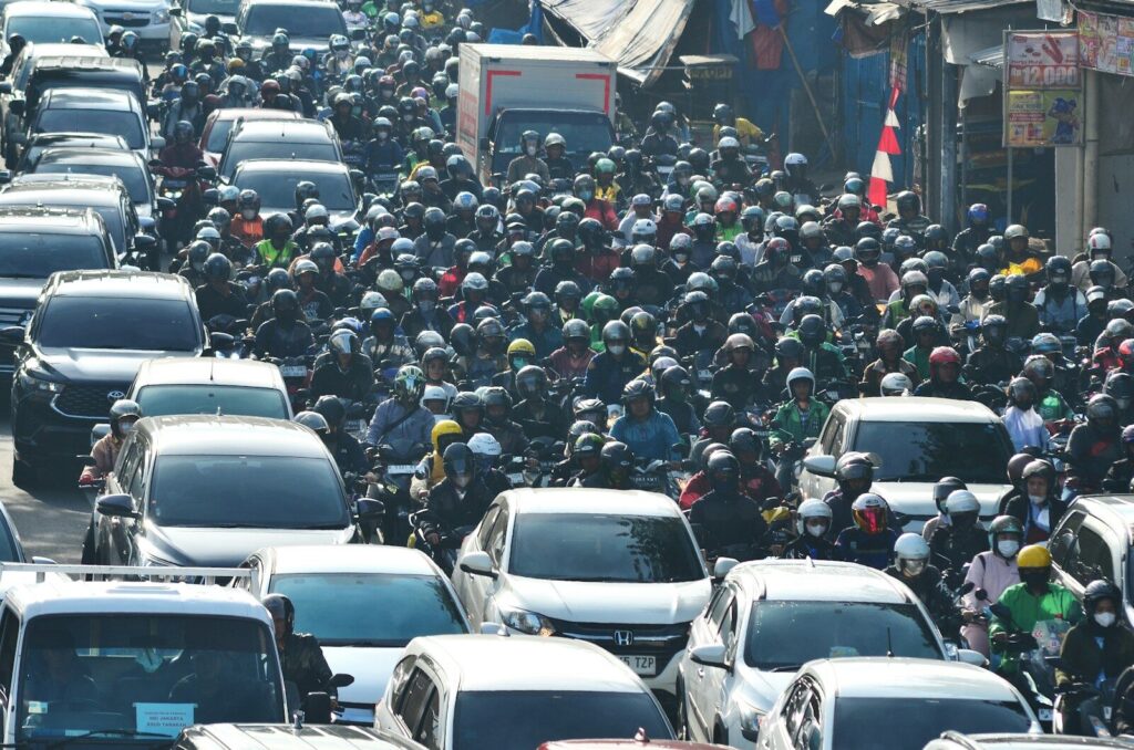 A large group of cars driving down a street