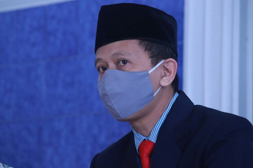 man in black suit wearing white face mask